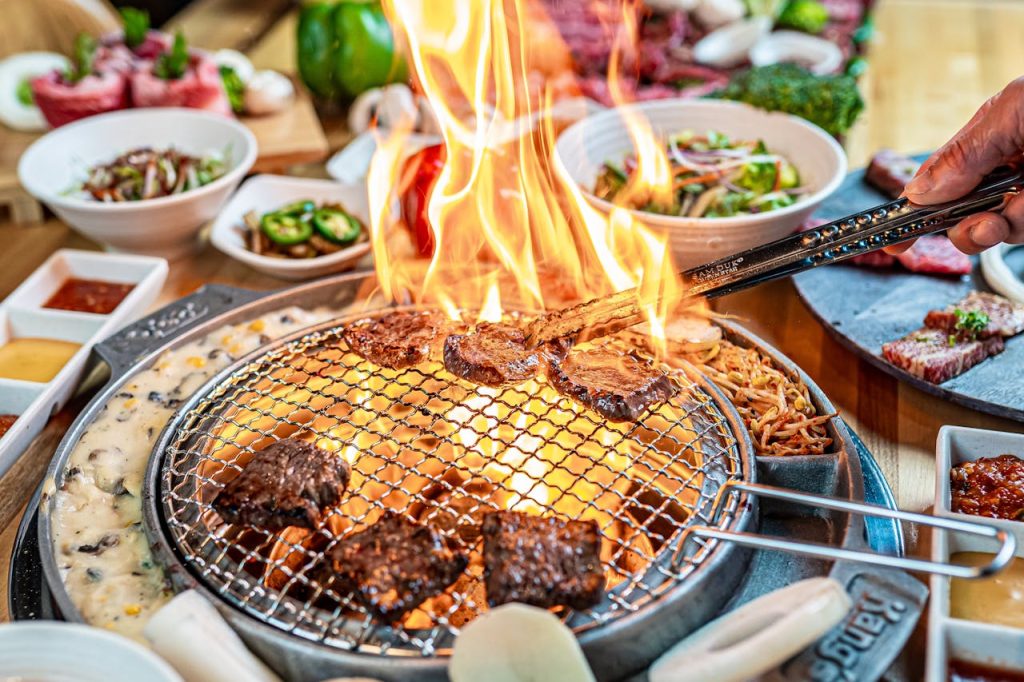 Delicious Korean BBQ with sizzling meat on the grill, surrounded by vibrant side dishes.
